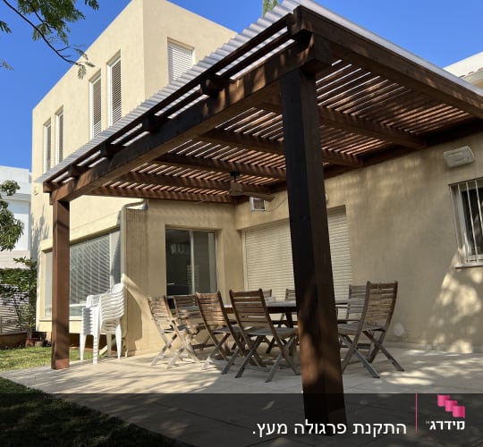 פרגולה מעץ מעל שולחן וכיסאות בגינה